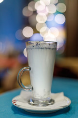 Hot milk drink with blue flowers. Shallow depth of field