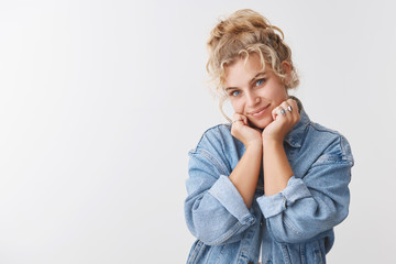 Cute tender feminine delightful pretty blond curly-haired scandinavian woman blue eyes gazing flirty camera tilt head lean face palms flirting, romantic eye contact, acting innocent coquettish