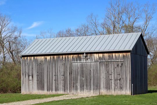 The old wood barn in the country on a bright sunny day.