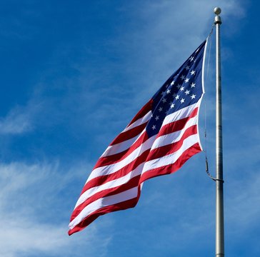 A View Of The United State Flag Flying In The Wind.