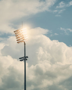 Stadium floodlights against cloudy sky