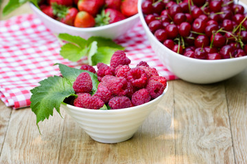 Organic raspberry, sour cherry andstrawberry on rustic table - healthy food