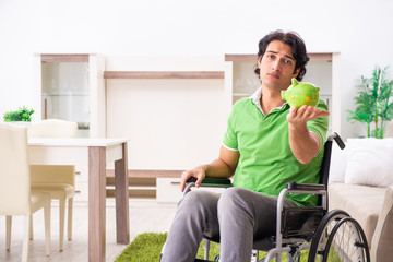 Young handsome man in wheelchair at home 