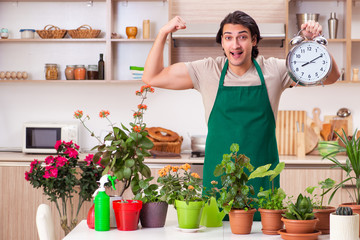 Young handsome man cultivating flowers at home