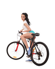 Fototapeta na wymiar Young seductive woman in sport wear posing on the bicycle