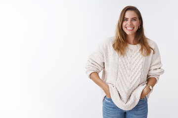 Cute positive enthusiastic charming caucasian woman casually standing white background good mood...