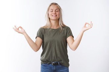 Peaceful young attractive 25s woman with blond hair inhaling fresh air close eyes and smiling...