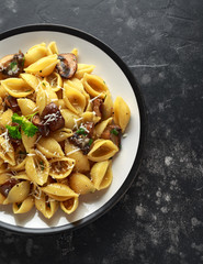 Conchiglie pasta with mushrooms, creamy sauce, parmesan cheese and herbs