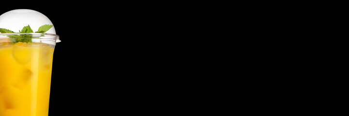 Delicious fruit cocktail in a plastic cup, on a black background. Smoothie Banner.