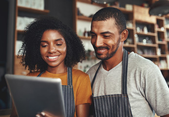 New business owners using tablet in cafe