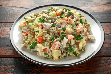Russian traditional salad Olivier with vegetables and meat.