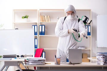 Professional contractor doing pest control at office 