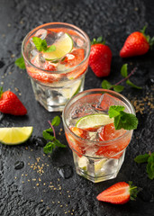 Strawberry Mojito cocktail with Rum, lime and mint in glass. Summer cold drink with ice
