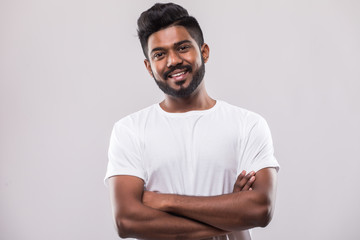 Portrait of happy handsome bearded man standing in crossed hands and smiling isolated on white background.