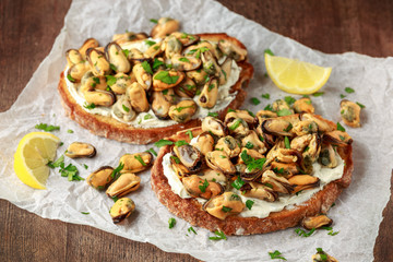 Homemade Mussels on grilled bruschetta, toast with soft cheese and herbs