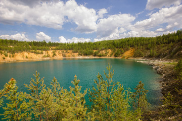 Open pit mining gold quarry with blue water