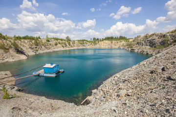 Open pit mining gold quarry with blue water