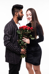 They are as beautiful as you. Full length of indian man giving a bouquet of red roses for his asian woman isolated on white background