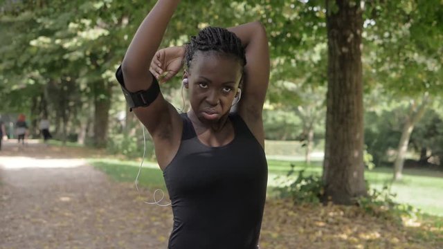 young african athlete does stretching in the park-slow motion
