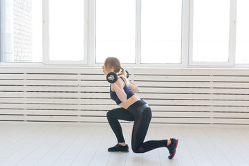 Fototapeta premium Fitness, sport and people concept - smiling sporty woman with barbell doing split squat or lunge