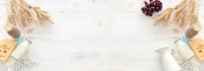 top view photo of dairy products over white wooden background. Symbols of jewish holiday - Shavuot