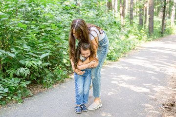 Family, nature, people concept - mother and daughter hugging in the park