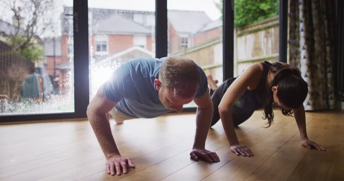 4K Fitness couple doing push ups together with girl failing to keep up with the pace. Slow motion.