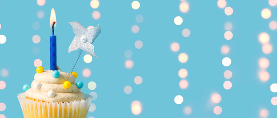 Celebratory cupcake with a decorative lit candle