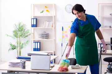 Male handsome professional cleaner working in the office 