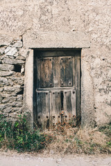 Wooden old door on a stone wall