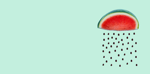 Watermelon and seeds rain concept on a green background