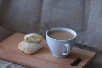 coffee and bun on a wooden cutting Board on a canvas background