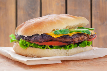fresh flavored cheeseburger with juicy cutlet, cucumbers, tomato and lettuce