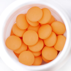 top view of orange pills in white bottle