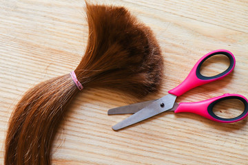 hair cropped on a light background with scissors. Blonde hair cropped