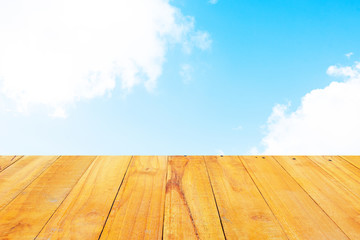Old Wooden table with blue sky white cloud background.