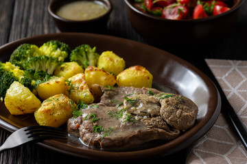 Slow roast leg of lamb with roasted potatoes and broccoli.