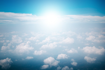 View of the sky clouds above the clouds from airplane window with sun light retro color filter