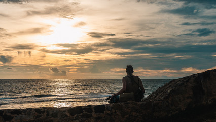 Naklejka na ściany i meble man sitting on a castle wall against sunset in Galle, Sri Lanka