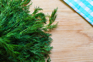 green fresh dill on a light wooden background