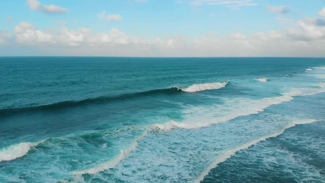aerial footage of breaking waves in the morning at Melasti Beach in Uluwatu, Bali