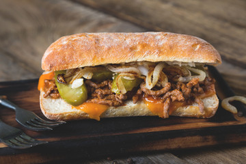 Big sandwich with meat, onions and cheddar cheese