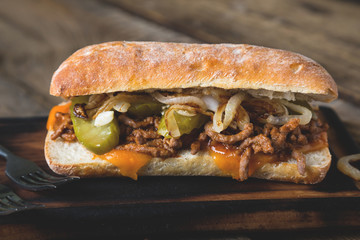 Big sandwich with meat, onions and cheddar cheese