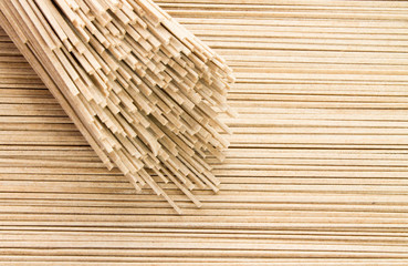 Dried buckwheat soba noodles background, top view with bundle. Flat lay, overhead.