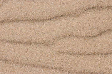 Fototapeta na wymiar wavy sand texture and background structure, close-up of detail