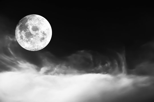 Dramatic atmosphere panorama view of black and white soft cloud and full moon image on night background. Image of moon furnished by NASA.