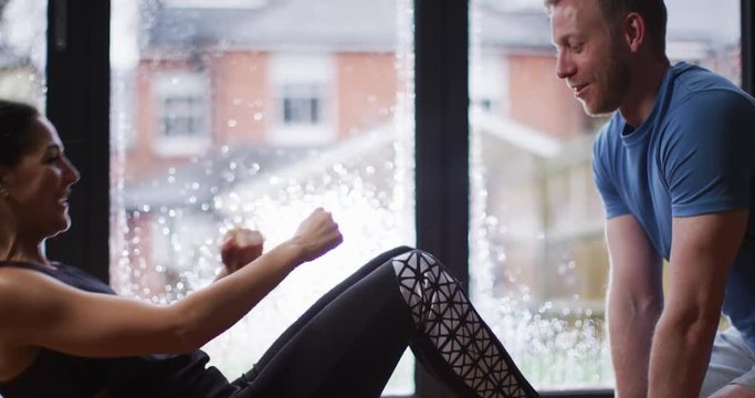 4K Happy attractive couple in a relationship exercising together at home. Slow motion.
