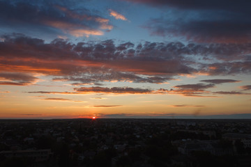 Colorful sunset. Clouds in the evening sky. View from the roof of a multistory building. Ukraine