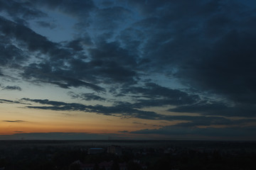 Fototapeta na wymiar Colorful sunset. Clouds in the evening sky. View from the roof of a multistory building. Ukraine