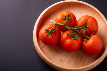Tomato vegetables on wooden plate close up angle view